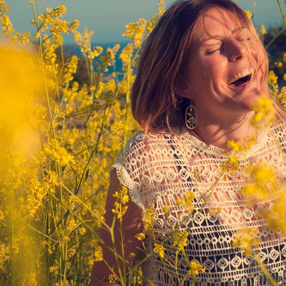 Jamie Grace Davis laughing in a field of yellow wildflowers